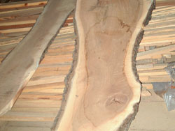 Wide plank walnut boards cut from logs with character.